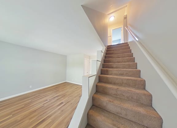 a staircase in a home with wood floors and white walls
