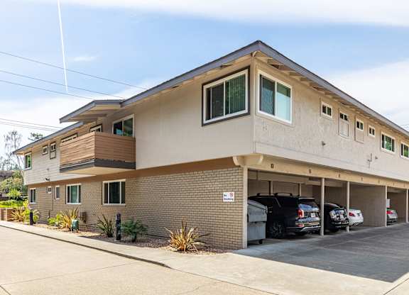 A two-story building with a parking garage in front.
