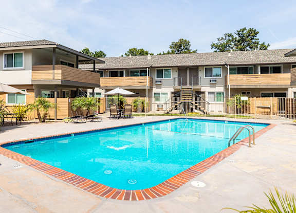 A swimming pool in front of apartment buildings.