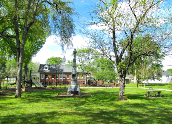 a park with a statue and a building in the background