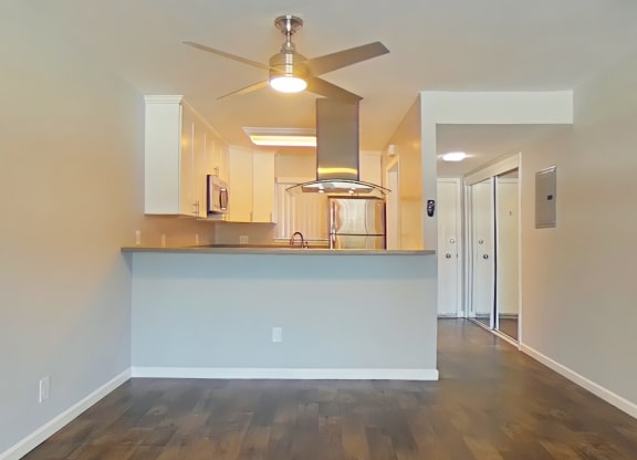 A kitchen with a white counter and a ceiling fan.