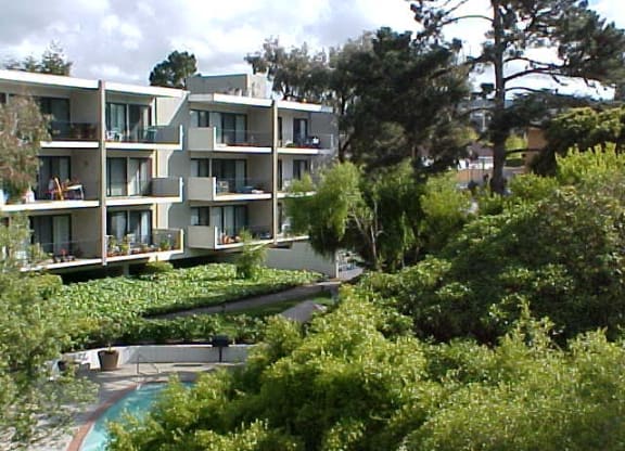 a view of an apartment building with trees in the foreground