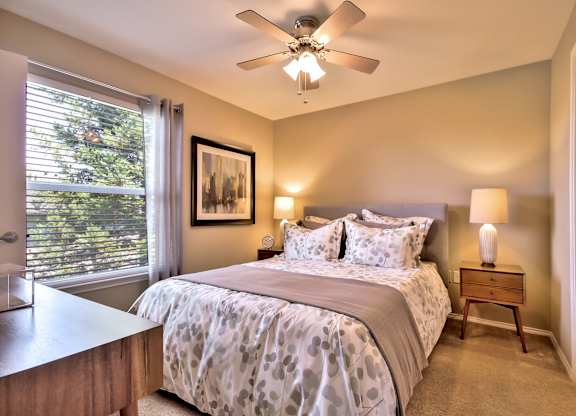 Bedroom with ceiling fan and neutral decor at Rosemeade Apartments, Roseville