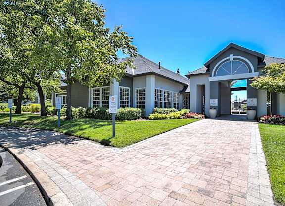 Leasing office entrance with paver walkway and landscaping at Rosemeade Apartments, California, 95661