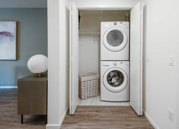 A laundry room with a washer and dryer stacked on top of each other.