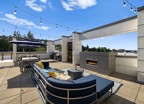 A patio with a couch and a fireplace.