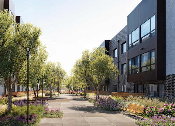 A modern building complex with a tree-lined walkway in front.