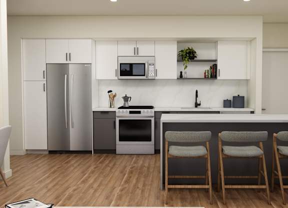 A modern kitchen with a refrigerator, microwave, oven, and bar stools.