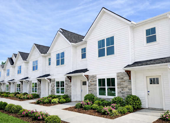 white houses with green bushes in front at Ventura Townhouses, West Olive