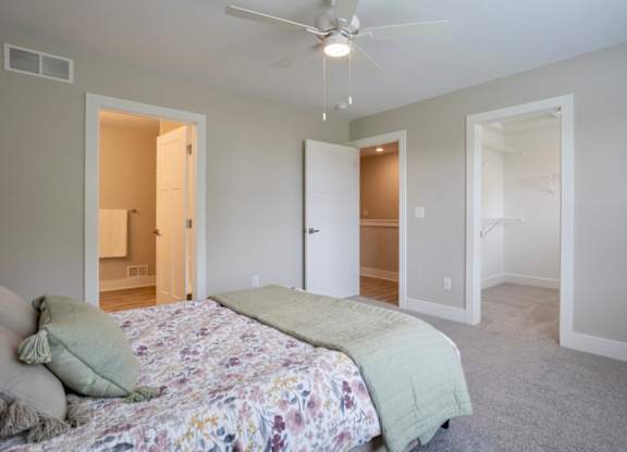 A bedroom with a bed in the center and a ceiling fan above it at Ventura Townhouses, West Olive  , MI, 49460