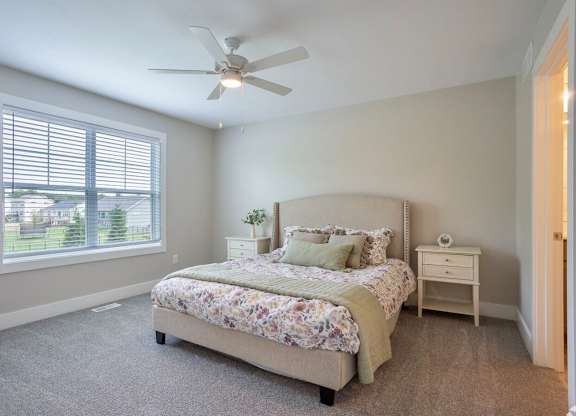 A bedroom with a large bed and a ceiling fan at Ventura Townhouses, Apartments, West Olive  , MI