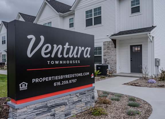 A sign for Ventura Townhouses with a website and phone number.