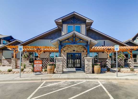 A building with a blue sign that says "Now Open" in front of it.