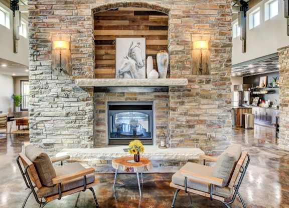 A stone fireplace with a fire going in it.