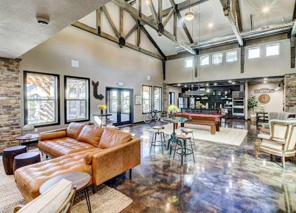 A living room with a brown leather couch and a wooden floor.