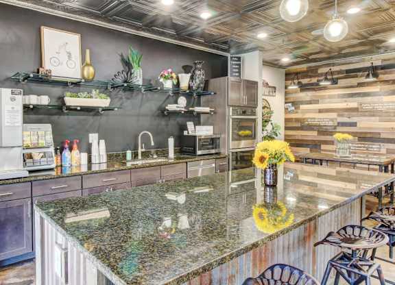 A kitchen with a granite countertop and wooden wall paneling.
