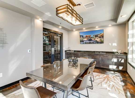 A modern dining room with a glass table and chairs.