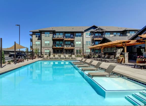 A large swimming pool in front of a multi-story building.