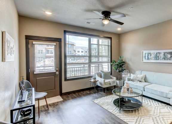 A living room with a white couch, a coffee table, and a ceiling fan.