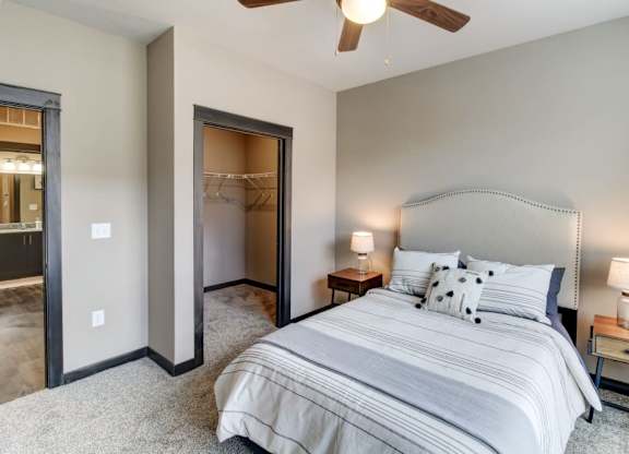 A bedroom with a large bed and a ceiling fan.