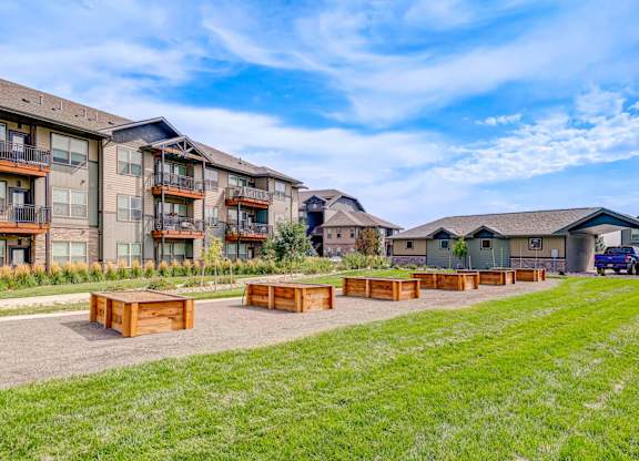 A row of modern apartment buildings with a grassy area in front.