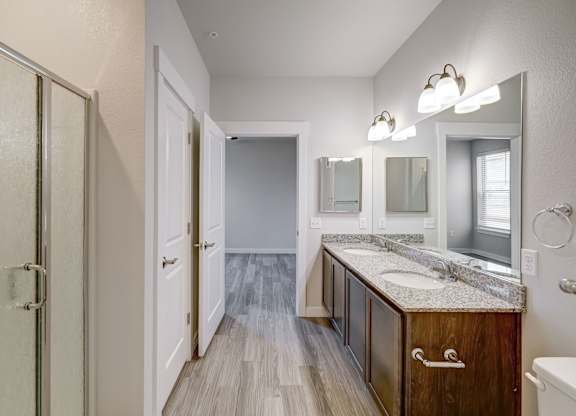 A bathroom with a sink, mirrors, and a wooden cabinet.