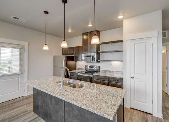 A kitchen with a granite countertop and a sink.
