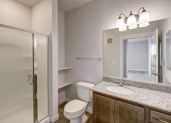 A bathroom with a toilet, sink, and mirror.