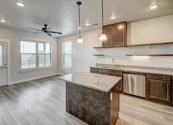 A kitchen with a marble island and stainless steel appliances.