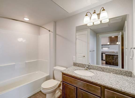 A white bathroom with a toilet, sink, and bathtub.