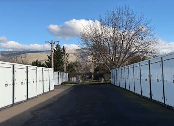 A long row of white storage units line a road.