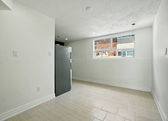 A room with a fridge and a window.