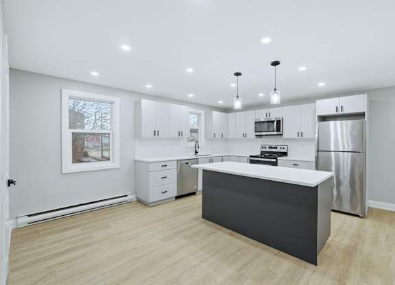 A kitchen with a refrigerator, microwave, and oven.