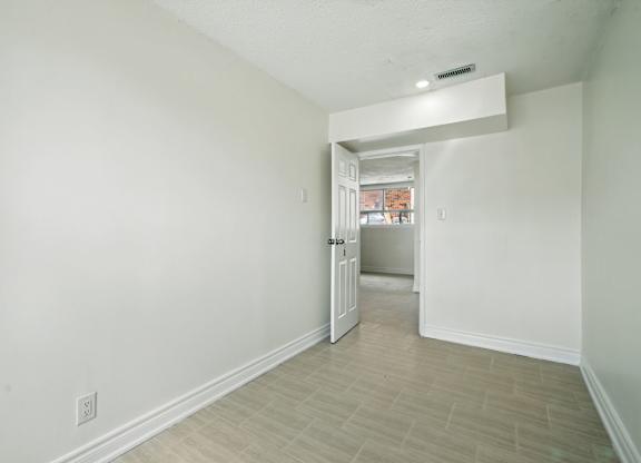 A white room with a doorway leading to another room.