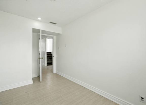 A white room with a doorway leading to another room.
