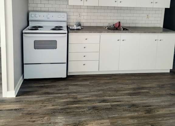 A white kitchen with a stove and cabinets.