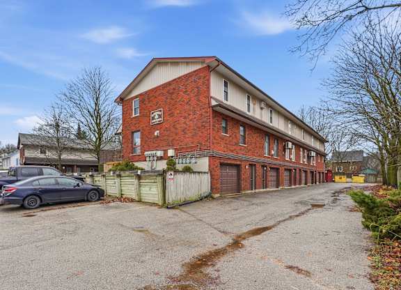 A red brick building with a car parked in front.