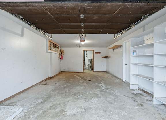 A room with a white wall and a door in the middle.