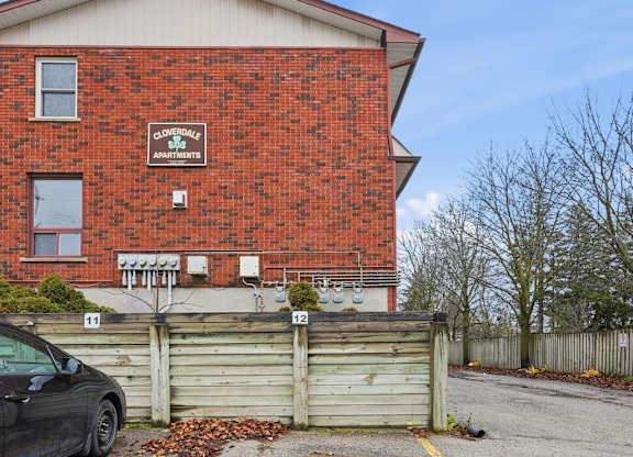 A red brick building with a black car parked in front of it.