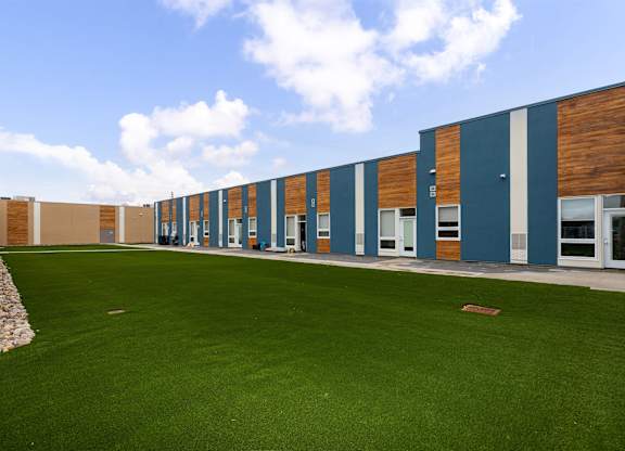 A long building with a green lawn in front.