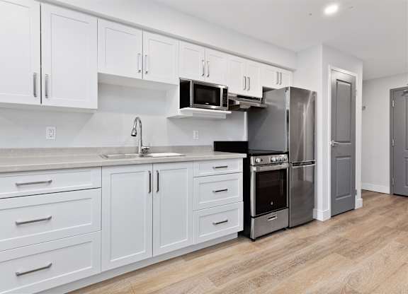 A kitchen with white cabinets and stainless steel appliances.