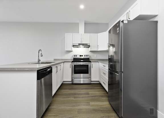 A modern kitchen with stainless steel appliances and white cabinetry.