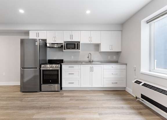 A modern kitchen with white cabinets and stainless steel appliances.
