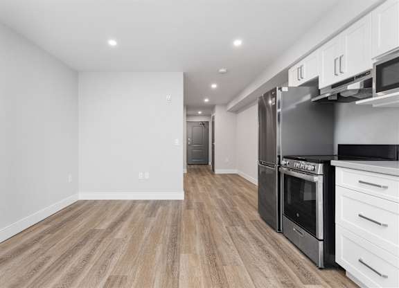 A kitchen with a refrigerator, oven, and microwave.