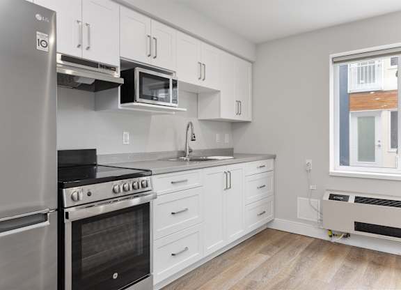 A kitchen with white cabinets and stainless steel appliances.