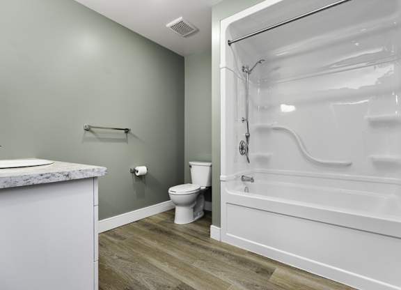 A white bathroom with a toilet, sink, and bathtub.