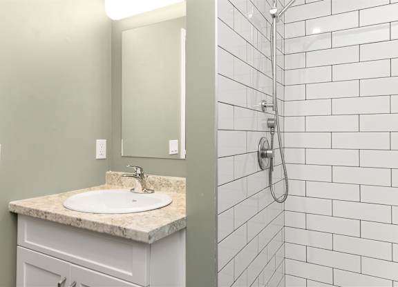 A white sink with a marble counter top in a bathroom.