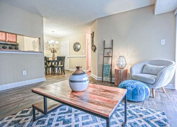 A living room with a wooden coffee table and a blue patterned rug.