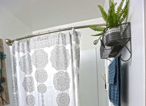 A white toilet in a bathroom with a shower curtain and a plant.