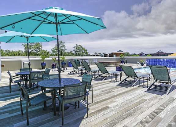 A patio with a table and chairs and a blue umbrella.